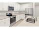 Bright kitchen with stainless steel appliances, quartz counters and white cabinets at 20387 Symphony Pl, Venice, FL 34293