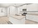 Bright kitchen boasts white cabinets, stainless steel appliances and center island sink at 20387 Symphony Pl, Venice, FL 34293