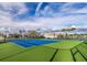 Outdoor tennis courts surrounded by landscaping and blue skies at 20387 Symphony Pl, Venice, FL 34293