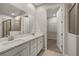 Elegant bathroom with double vanity, large mirror, and a walk-in closet at 20405 Symphony Pl, Venice, FL 34293
