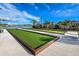 Bocce ball court with manicured lawns and a water view, perfect for leisure activities and community gatherings at 20405 Symphony Pl, Venice, FL 34293
