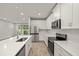 Bright kitchen featuring stainless steel appliances, quartz countertops, island with sink and an open layout at 20405 Symphony Pl, Venice, FL 34293