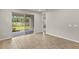 Open-concept living room with wood look tile flooring, neutral paint, and sliding glass door access to the outdoor space at 20405 Symphony Pl, Venice, FL 34293