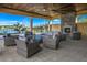 Covered outdoor patio with wicker seating and a stone fireplace, perfect for relaxing and entertaining guests at 20405 Symphony Pl, Venice, FL 34293