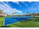 Well-maintained tennis court with green turf and blue court surface, promoting an active and engaging community lifestyle at 20405 Symphony Pl, Venice, FL 34293