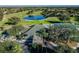 Elevated view of the golf course, pond, and clubhouse surrounded by mature trees at 23717 Coral Ridge Ln, Land O Lakes, FL 34639