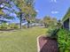 Scenic backyard view with lush lawn, mature trees, and pond at 23717 Coral Ridge Ln, Land O Lakes, FL 34639