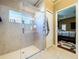 Bathroom featuring a glass-enclosed shower, neutral tile, and a view into the bedroom at 23717 Coral Ridge Ln, Land O Lakes, FL 34639