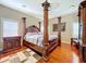 Elegant bedroom with hardwood floors, four-poster bed, and refined furnishings at 23717 Coral Ridge Ln, Land O Lakes, FL 34639