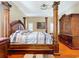 Bedroom featuring a four-poster bed, hardwood floors, and neutral color palette at 23717 Coral Ridge Ln, Land O Lakes, FL 34639
