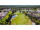 Aerial view of a lush golf course winding through a community, bordered by a pond and tree lined streets at 23717 Coral Ridge Ln, Land O Lakes, FL 34639