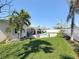 View of the fenced-in backyard featuring a freeform swimming pool and covered patio with seating at 2593 W Vina Del Mar Blvd, St Pete Beach, FL 33706