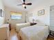 Comfortable bedroom with twin beds, wood floors, and a bright window at 2593 W Vina Del Mar Blvd, St Pete Beach, FL 33706