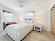 Bright bedroom with a white bed, matching nightstands, and wood-look flooring at 2593 W Vina Del Mar Blvd, St Pete Beach, FL 33706