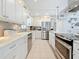 Bright kitchen featuring white cabinets, stainless steel appliances, and marble countertops at 2593 W Vina Del Mar Blvd, St Pete Beach, FL 33706