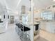Spacious kitchen with island and seating, featuring white cabinets and stainless steel appliances at 2593 W Vina Del Mar Blvd, St Pete Beach, FL 33706