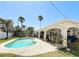 Inviting backyard pool with lush tropical landscaping and covered patio at 2593 W Vina Del Mar Blvd, St Pete Beach, FL 33706