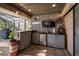 Outdoor bar area with corrugated metal finish, mini-fridge, tv, and vintage barrel decor at 2604 Manor Oak Dr, Valrico, FL 33596