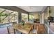 Covered outdoor patio with a wooden table and chairs next to an in-ground pool with screen enclosure at 2889 Knollwood Ct, Clearwater, FL 33761