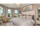 Luxurious main bedroom featuring a chandelier, plush bedding, large windows, and stylish decor at 29505 Velletri Ln, Wesley Chapel, FL 33543