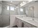 The bright bathroom showcases a walk-in shower with glass doors and a dual sink vanity with modern fixtures at 319 Shore Crab Way, Apollo Beach, FL 33572