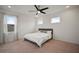 Bright bedroom features plush carpet, a modern ceiling fan, and natural light from well-placed windows at 319 Shore Crab Way, Apollo Beach, FL 33572