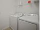 Functional laundry room with washer, dryer, and shelving at 319 Shore Crab Way, Apollo Beach, FL 33572