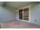 Covered patio with stylish brick flooring and sliding glass doors leading indoors at 319 Shore Crab Way, Apollo Beach, FL 33572