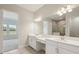 Bathroom with dual sinks, vanities, and a tiled shower at 35587 Stableton Ln, Zephyrhills, FL 33541
