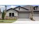 Charming single-Gathering home featuring a gray exterior, tile roof, and paved driveway at 35587 Stableton Ln, Zephyrhills, FL 33541
