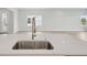 Bright, modern kitchen featuring a stainless steel sink and hardware with laminate flooring at 35587 Stableton Ln, Zephyrhills, FL 33541