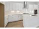 Modern kitchen featuring white cabinets, stainless steel appliances, and a herringbone backsplash at 35587 Stableton Ln, Zephyrhills, FL 33541