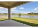 View from covered patio overlooking grassy lawn and water feature at 35587 Stableton Ln, Zephyrhills, FL 33541