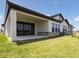 Backyard patio with a covered porch, sliding glass doors, and landscaped yard at 35593 Stableton Ln, Zephyrhills, FL 33541