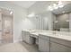 Bathroom featuring double sink vanity, gray cabinets, quartz countertop, and large mirror at 35593 Stableton Ln, Zephyrhills, FL 33541