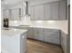 Well-equipped kitchen with grey cabinetry, stainless steel appliances, and a bright white backsplash at 35593 Stableton Ln, Zephyrhills, FL 33541