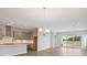 Open-concept living space with modern kitchen, dining area, and views of the outdoor scenery at 35593 Stableton Ln, Zephyrhills, FL 33541