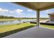 Covered patio offers beautiful lake views, landscaped backyard and privacy fence at 35593 Stableton Ln, Zephyrhills, FL 33541