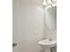 Elegant powder room with pedestal sink, round mirror, stylish lighting and fresh modern look at 35593 Stableton Ln, Zephyrhills, FL 33541