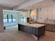 Open-concept kitchen featuring a large island, white cabinets, and natural light at 3904 W Vasconia St, Tampa, FL 33629