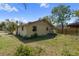 Rear exterior of the house with small windows and overgrown vegetation at 4020 Amber Rd, Valrico, FL 33594