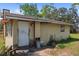 Exterior rear view with a white door and plywood siding at 4020 Amber Rd, Valrico, FL 33594