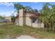 Exterior home view with a chimney, small door, and a metal building in the background at 4020 Amber Rd, Valrico, FL 33594