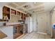 Renovation view of kitchen area, including cabinets with a white refrigerator and tiled flooring at 4020 Amber Rd, Valrico, FL 33594