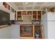 View of the kitchen features open cabinets, white refrigerator, and white tile floors at 4020 Amber Rd, Valrico, FL 33594
