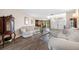 Bright living room with wood-look tile flooring, comfortable sofas, glass-top table, and chandelier at 5806 Dory Way, Tampa, FL 33615