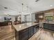 Kitchen island with granite countertop and dark wood cabinetry overlooking living space at 858 Vino Verde Cir, Brandon, FL 33511