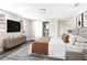 Stylized bedroom features neutral walls, TV, bed, rug, base trim and gray, wood-look vinyl floors at 9315 N 19Th St, Tampa, FL 33612