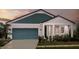 Inviting single Gathering home with a charming entry, blue garage door, and manicured lawn at 10267 Fieldstone Myrtle Way, San Antonio, FL 33576