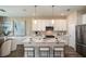 Bright, white kitchen featuring stainless steel appliances, a large island, and modern pendant lighting at 10267 Fieldstone Myrtle Way, San Antonio, FL 33576
